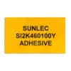 A yellow rectangular label, 100mm x 60mm, with adhesive backing, suitable for panels and equipment. The label has SUNLEC SI2K460100Y ADHESIVE printed on it.